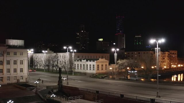 Yekaterinburg, Russia, Lenina street at night. Stock footage. Aerial view of an empty wide city street with lanterns on the background of black sky and skyscrapers.