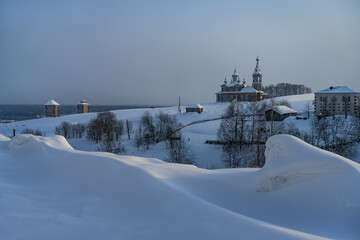 Obraz premium Panoramic view of the ancient city of Cherdyn (Northern Ural Russia), located on several hills. Historic center with beautiful wooden churches and houses and deep snow on a winter day 