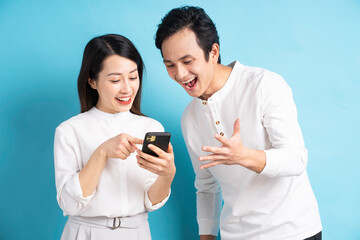 Portrait of young couple using phone on background