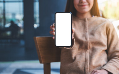 Mockup image of a beautiful asian woman holding and showing a mobile phone with blank white screen