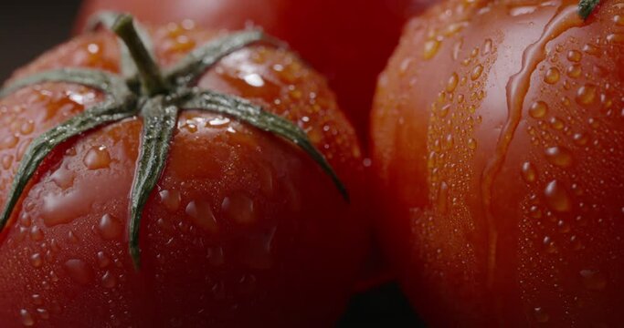Close up shot of tasty fresh organic tomato. Water drop slowly falling from juicy vegetable. Foof and drink, vegetarian products 4k footage