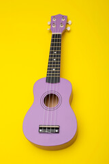 Obraz premium Four string ukulele guitar on yellow background