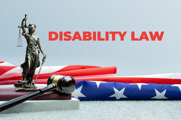 Disability law. Lady justice, judge gavel and books in front of a usa flag. Red text on gray...