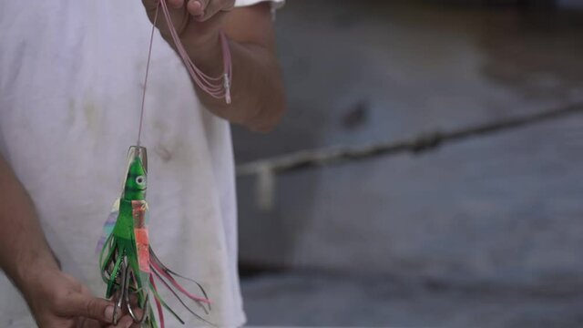 Man showcasing Large Green streamer fly Feather Fishing Hook in Hawaii - Close up shot