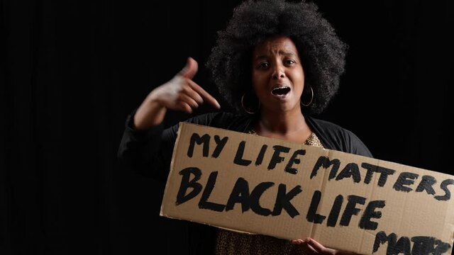 [4k] studio portrait of black life matters protester saying parole holding a cardboard sign