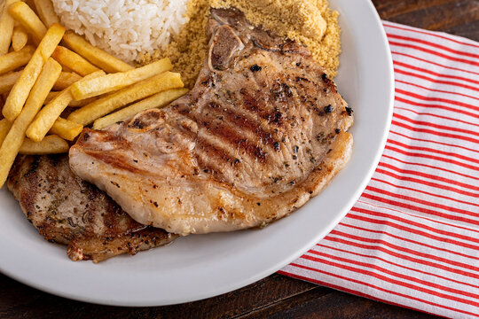 Bisteca su&iacute;na com farofa, batata frita e arroz