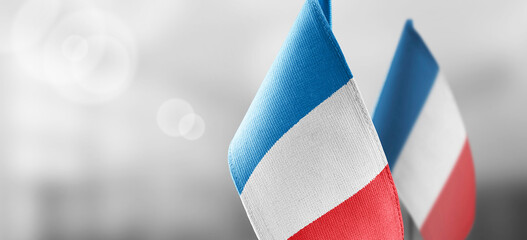 Small national flags of the France on a light blurry background