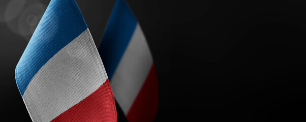 Small national flags of the France on a dark background
