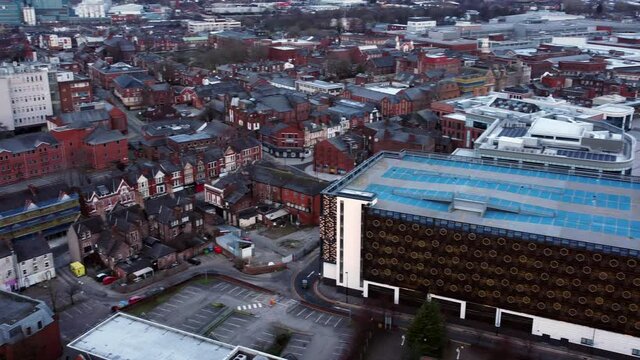 Early morning aerial Warrington England city street multi-storey carpark rooftop townscape pan left