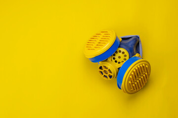 Respirator type half mask with replaceable filters on yellow background.