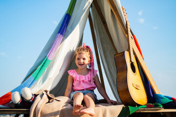 Smiling kid in tent. Girl playing in camp. Kids camping. Having fun outdoors. Campground.