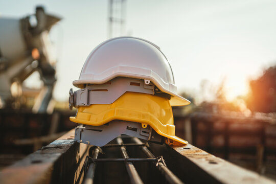 white and yellow helmet on steel in construction site