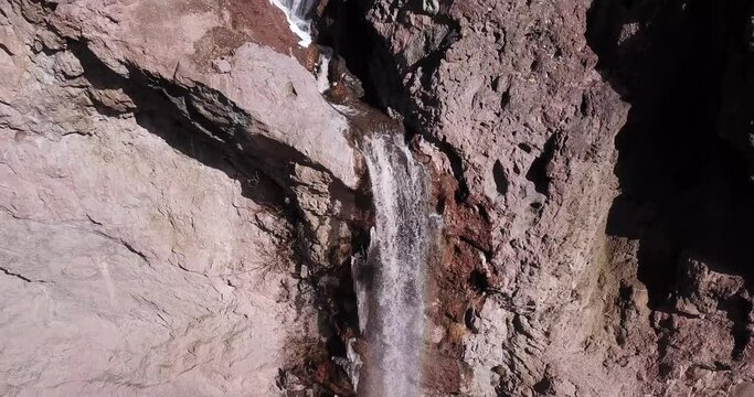 Narrow river flow through a beautiful valley in Alborz mountain fall down the cliff waterfall in cold winter with icy frozen icicle and splash waters in Alamut valley Qazvin Iran