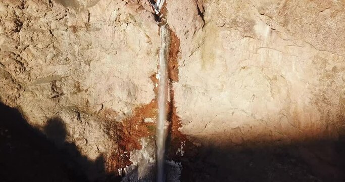 fly toward a high waterfall in sunset in Alamut death valley in Iran. sunset time in winter with frost cold weather in wild nature.