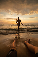 woman silhouette on the beach at sunset with man Legs