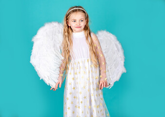 Looks like an angel. Face of beautiful little angel girl on color background. Angel. Child with...