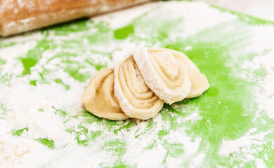 The raw dough bun is ready to be baked in the oven. The concept of baking buns at home.
