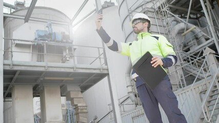 Engineer taking a photo with his mobile phone in a factory. Inspection concept in industry. Selective focus.