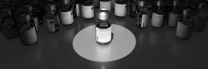 Labelled glass vials containing a generic Covid-19 vaccine. Spotlight and focus on a vial in the center.. Blurred Background.
