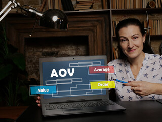 Businesswoman showing laptop with acronym  AOV Average Order Value on the screen