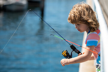 Child fishing on rod. Young fisher. Boy with spinner at river. Fishing concept.
