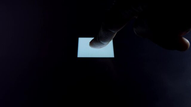 Human finger is pressing a digital button on a glowing touchscreen. Futuristic microprocessor is starting the operation of the computer program. Machine learning and artificial intelligence.