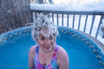 Lady, woman posing, smiling for camera with frozen, frosty, ice dripping hair. Taken in northern...