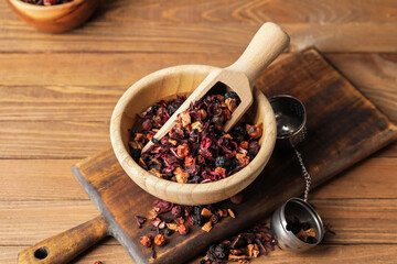 Bowl with dry fruit tea on wooden background
