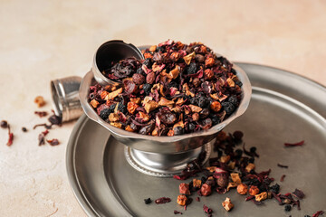 Bowl with dry fruit tea on light background