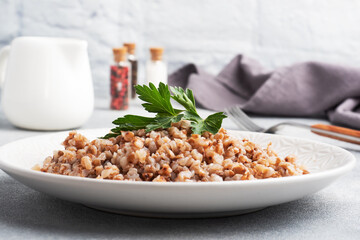 Boiled buckwheat on a plate. Healthy porridge enriched with vitamins.