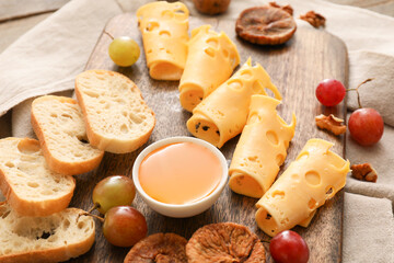 Composition with pieces of tasty cheese and grapes on wooden background