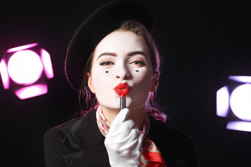 Female pantomimist with lipstick on dark background