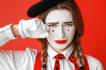 Crying female pantomimist on color background