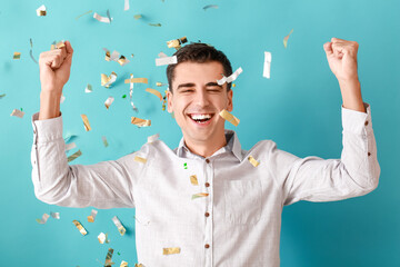 Happy man and falling confetti on color background