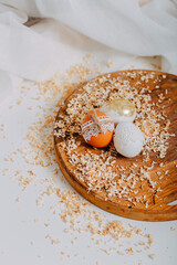 Three easter eggs on wooden background with sawdust around. Happy Easter card. Easter eggs with lace border, wooden cutting board on white table. Eggs decoration. Golden easter egg.