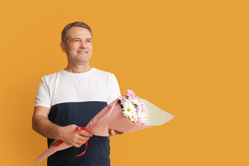 Mature man with bouquet of beautiful flowers on color background