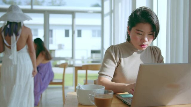 attractive asian female use laptop working online conference meeting social distancing new normal working lifestyle,asian woman working near big glass window morning time