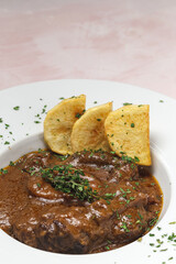 Homemade stew of osso buco meat with aromatic herb sauce