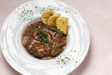 Homemade stew of osso buco meat with aromatic herb sauce