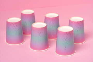 Pink disposable paper cups on pink background