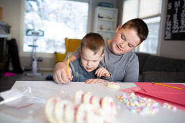 sister helping brother's write valentine's day notes