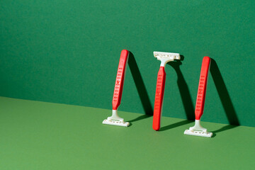Disposable razor on green background, studio shot