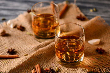 Scotch on wooden background with copyspace. Whiskey in shot glasses. Whiskey with cinammon and...