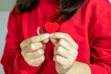 Red t-shirt girl holding a red heart by hand