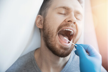 Medical test young man for dangerous corona virus using test swab stick