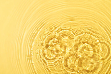 Transparent and clean yellow water background with sunlight reflection