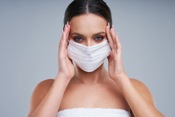 Portrait of beautiful woman in mask on gray background