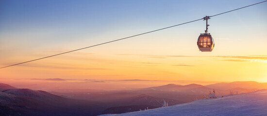 Colorful winter sunset lift ski resort in Sheregesh mountains with clouds forest Russia