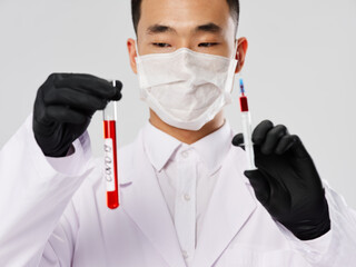 Male laboratory assistant medical mask analyzes research diagnostics gray background