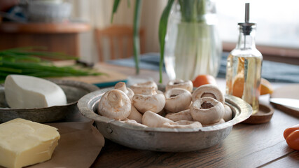 Champignon mushrooms on the table. Home kitchen. Sunny day. Soft focus in the background